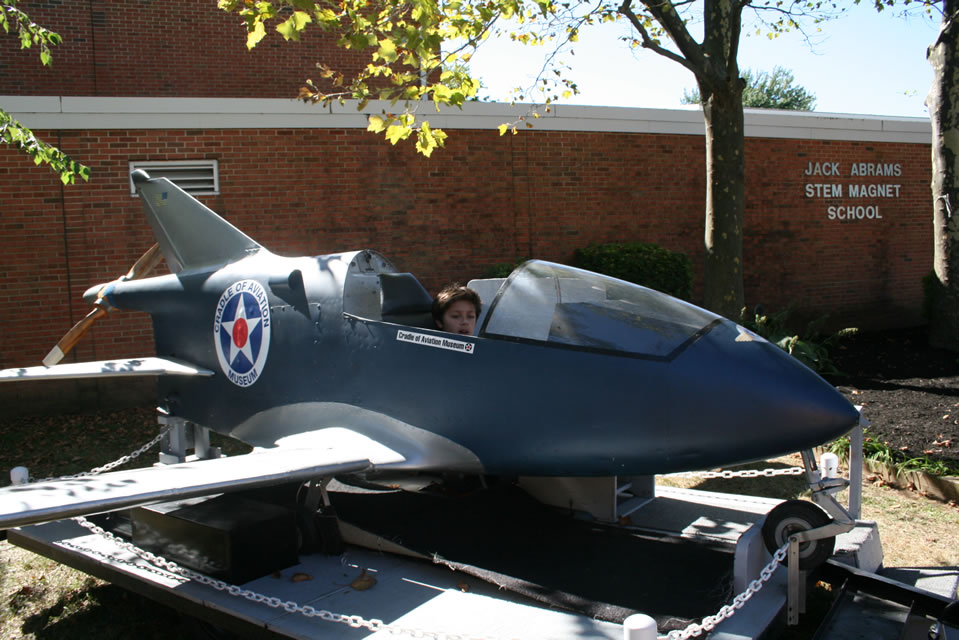 Nate Coulter seated in a Grumman aircraft at Jack Abrams STEM Magnet School